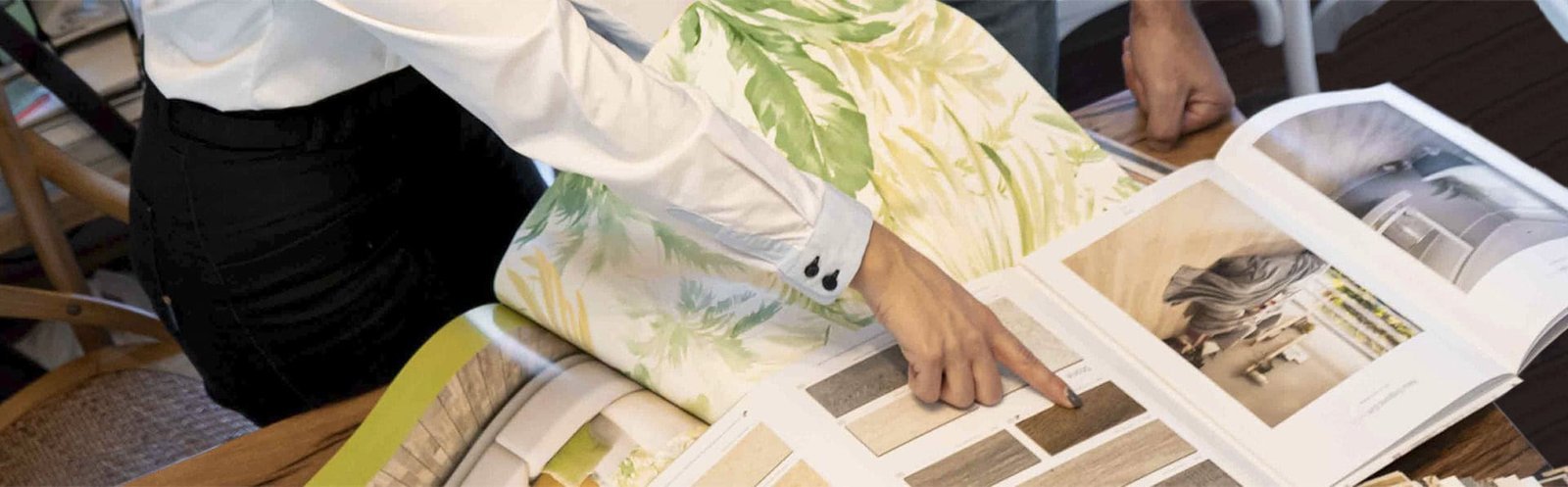 Persona señalando diseño en un catálogo.