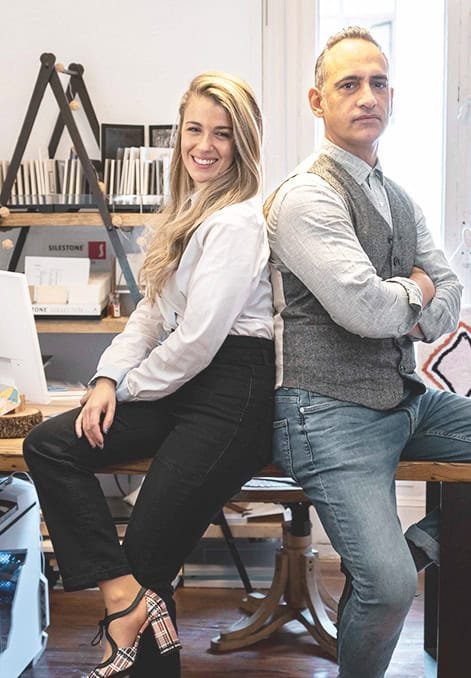 Personas sentadas espalda con espalda, sonriendo